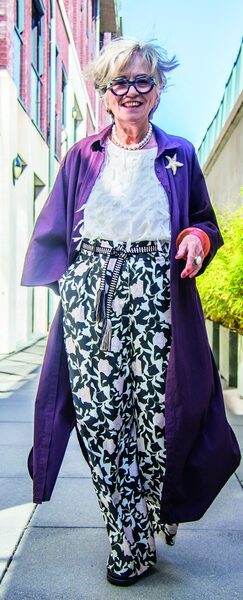 Misja Beijers in een kleurrijke outfit met opvallende sieraden en bril